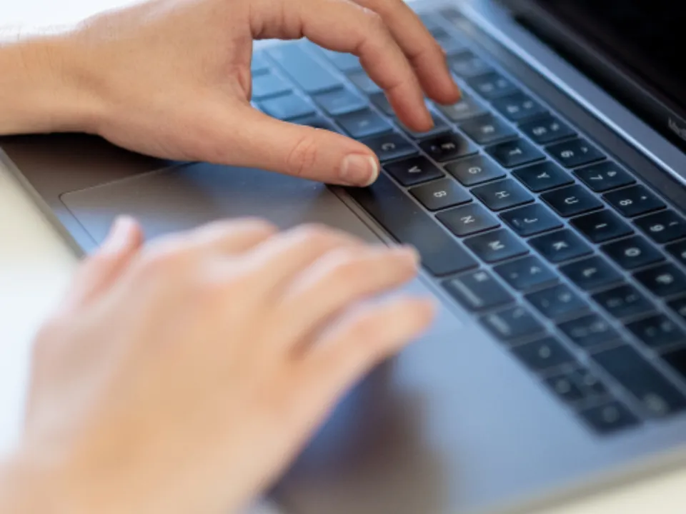 Hände auf einer Laptop-Tastatur